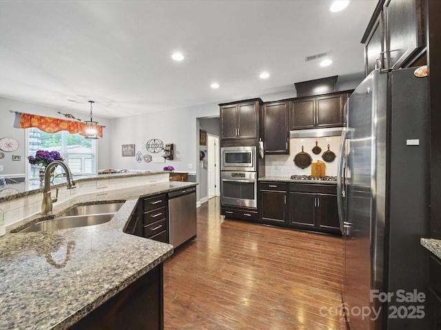 9450 Surface Hill Rd, Mint Hill, NC 28227 - kitchen with appliances with stainless steel finishes, backsplash, light stone countertops, dark wood-style flooring, and dark brown cabinetry