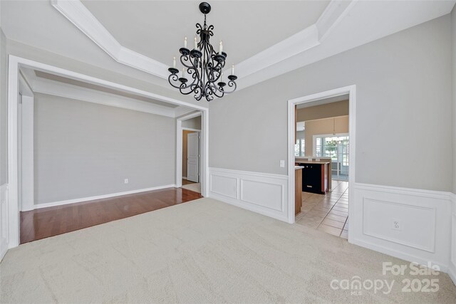 8409 Darcy Hopkins Dr, Charlotte, NC 28277 - unfurnished room featuring a chandelier, carpet flooring, wainscoting, a decorative wall, and crown molding