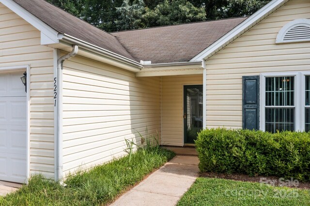 5221 Javitz Rd, Charlotte, NC 28216 - property entrance featuring an attached garage and a shingled roof