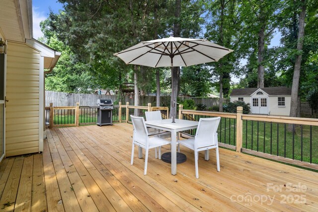 5221 Javitz Rd, Charlotte, NC 28216 - deck with outdoor dining space, a fenced backyard, an outbuilding, and grilling area