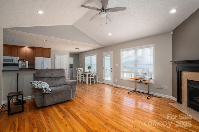 104 Nottingham Dr, Maiden, NC 28650 - living room with a fireplace with flush hearth, light wood-type flooring, a textured ceiling, a ceiling fan, and lofted ceiling