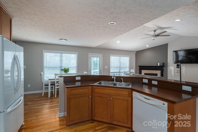 104 Nottingham Dr, Maiden, NC 28650 - kitchen featuring white appliances, a textured ceiling, open floor plan, light wood finished floors, and dark countertops