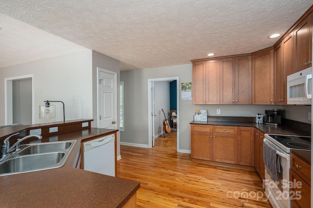 104 Nottingham Dr, Maiden, NC 28650 - kitchen featuring white appliances, dark countertops, light wood-style flooring, recessed lighting, and a textured ceiling