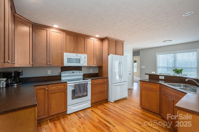 104 Nottingham Dr, Maiden, NC 28650 - kitchen with white appliances, a textured ceiling, dark countertops, light wood finished floors, and brown cabinets