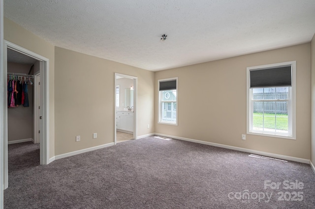 104 Nottingham Dr, Maiden, NC 28650 - unfurnished bedroom featuring carpet, a walk in closet, connected bathroom, a closet, and a textured ceiling