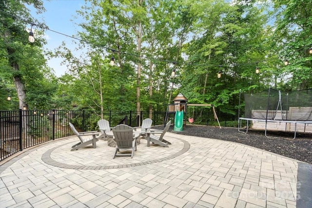 402 Wildlife Rd, Troutman, NC 28166 - view of patio / terrace featuring a trampoline, a playground, an outdoor fire pit, and view of scattered trees