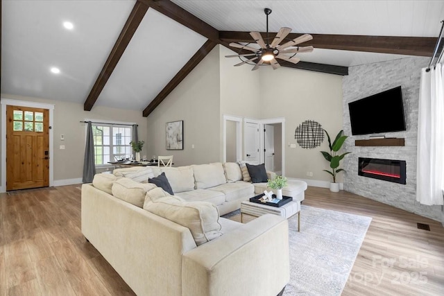 402 Wildlife Rd, Troutman, NC 28166 - living room featuring ceiling fan, beam ceiling, light wood-style floors, a stone fireplace, and high vaulted ceiling