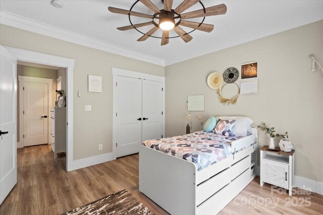 402 Wildlife Rd, Troutman, NC 28166 - bedroom featuring wood finished floors, crown molding, a closet, and a ceiling fan