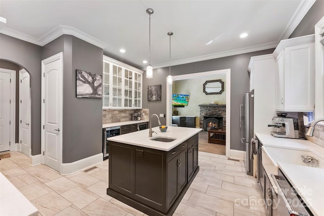 10007 Hillspring Dr, Huntersville, NC 28078 - kitchen with light countertops, white cabinets, wine cooler, a stone fireplace, and tasteful backsplash