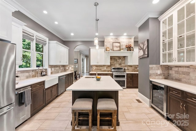 10007 Hillspring Dr, Huntersville, NC 28078 - kitchen featuring wine cooler, appliances with stainless steel finishes, light countertops, tasteful backsplash, and white cabinetry