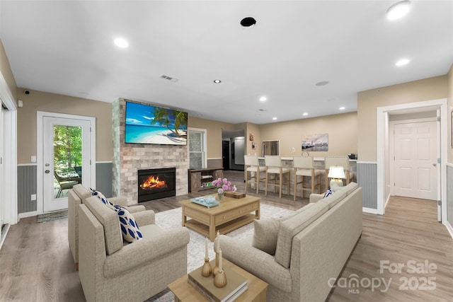 10007 Hillspring Dr, Huntersville, NC 28078 - living room featuring light wood-type flooring, wainscoting, a fireplace, and recessed lighting