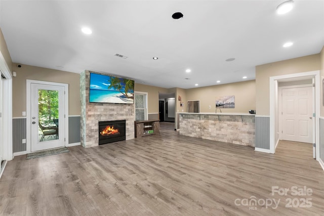 10007 Hillspring Dr, Huntersville, NC 28078 - unfurnished living room with light wood-type flooring, a fireplace, a wainscoted wall, and recessed lighting