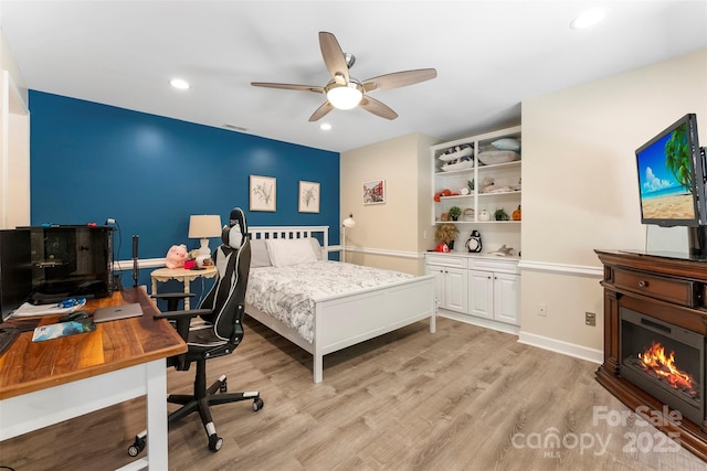 10007 Hillspring Dr, Huntersville, NC 28078 - bedroom featuring light wood-style floors, recessed lighting, a glass covered fireplace, a desk, and a ceiling fan