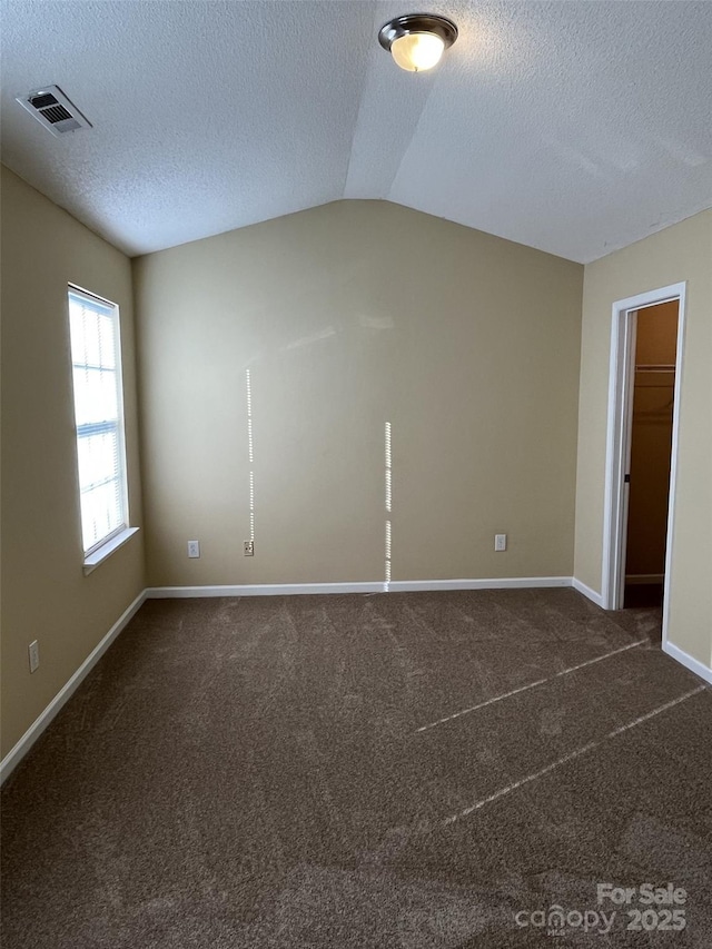 6130 Sid Crane Dr, Charlotte, NC 28216 - spare room with a textured ceiling, vaulted ceiling, and dark carpet