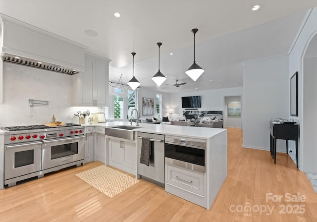 2837 Kenwood Sharon Ln, Charlotte, NC 28211 - kitchen featuring stainless steel appliances, a peninsula, light countertops, recessed lighting, and custom range hood