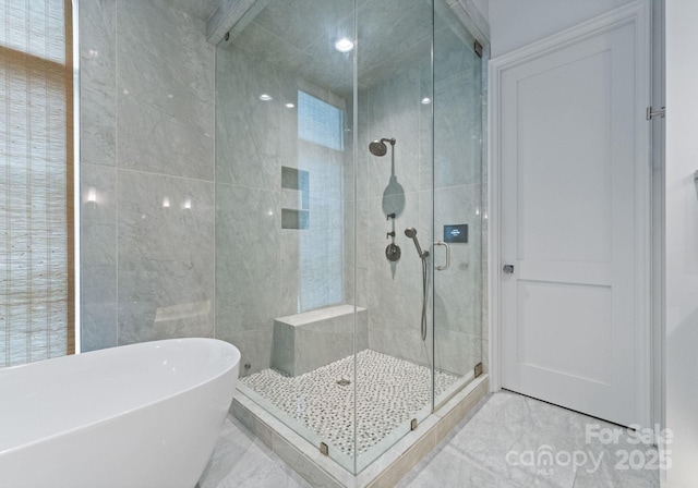 2837 Kenwood Sharon Ln, Charlotte, NC 28211 - bathroom with marble finish floors, a soaking tub, a shower stall, and tile walls