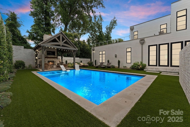 2837 Kenwood Sharon Ln, Charlotte, NC 28211 - pool at dusk featuring a warm lit fireplace, a lawn, a patio area, and a diving board