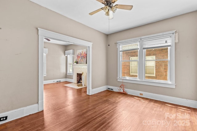 524 W Horah St, Salisbury, NC 28144 - unfurnished room with wood finished floors, a ceiling fan, a brick fireplace, and a wall mounted air conditioner