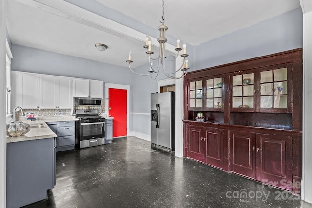 524 W Horah St, Salisbury, NC 28144 - kitchen with appliances with stainless steel finishes, a chandelier, dark floors, decorative backsplash, and decorative light fixtures