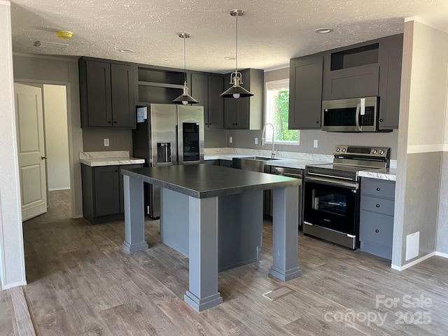 4172 Tallent Rd, Morganton, NC 28655 - kitchen featuring appliances with stainless steel finishes, a textured ceiling, light wood-style floors, open shelves, and a center island