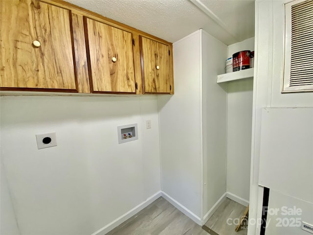 325 Scaley Bark Dr, Salisbury, NC 28147 - laundry room featuring hookup for a washing machine, light wood-type flooring, cabinet space, hookup for an electric dryer, and a textured ceiling