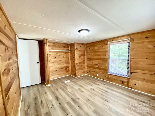 325 Scaley Bark Dr, Salisbury, NC 28147 - unfurnished bedroom featuring wood walls and light wood finished floors