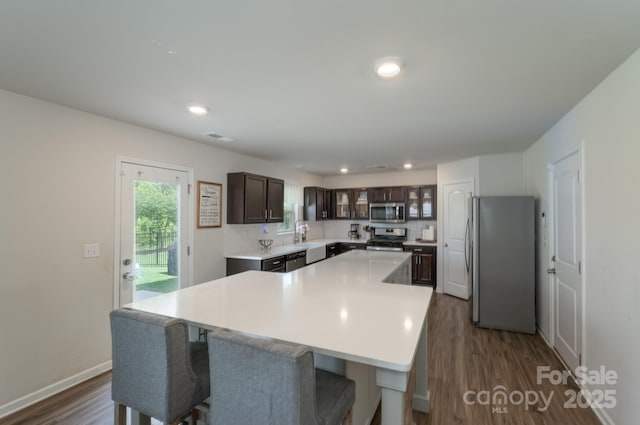 1736 Rhynes Trl, Rock Hill, SC 29732 - kitchen with appliances with stainless steel finishes, dark wood-type flooring, dark brown cabinets, a kitchen island, and light countertops