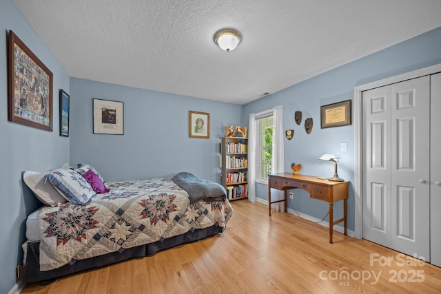 73 Waters Rd, Asheville, NC 28805 - bedroom with wood finished floors, a textured ceiling, and a closet