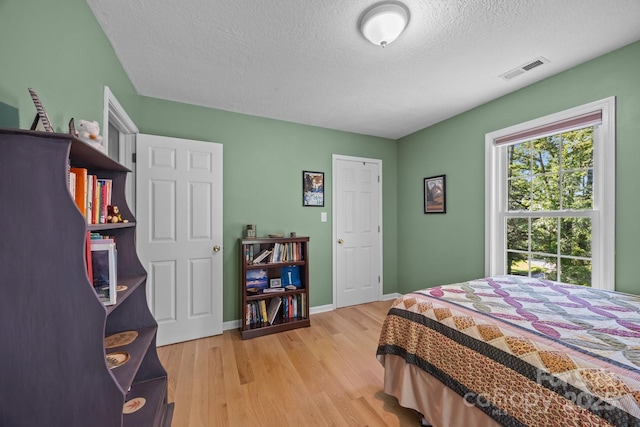 73 Waters Rd, Asheville, NC 28805 - bedroom with light wood finished floors and a textured ceiling