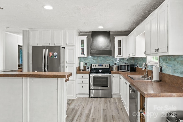 27 Sage Way, Clyde, NC 28721 - kitchen featuring stainless steel appliances, extractor fan, dark countertops, light wood-type flooring, and white cabinets