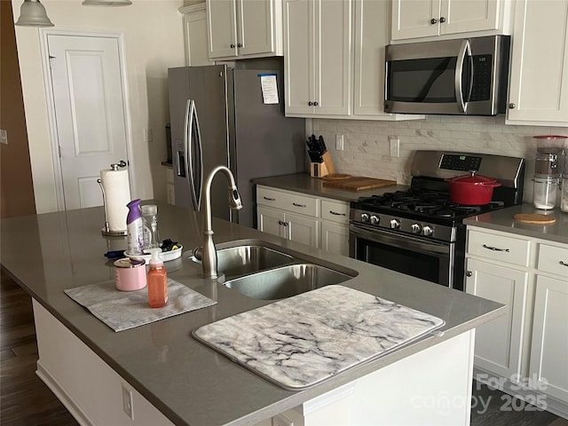 15005 Savannah Hall Dr Unit 72, Charlotte, NC 28273 - kitchen featuring appliances with stainless steel finishes, a center island with sink, backsplash, white cabinets, and dark wood-type flooring