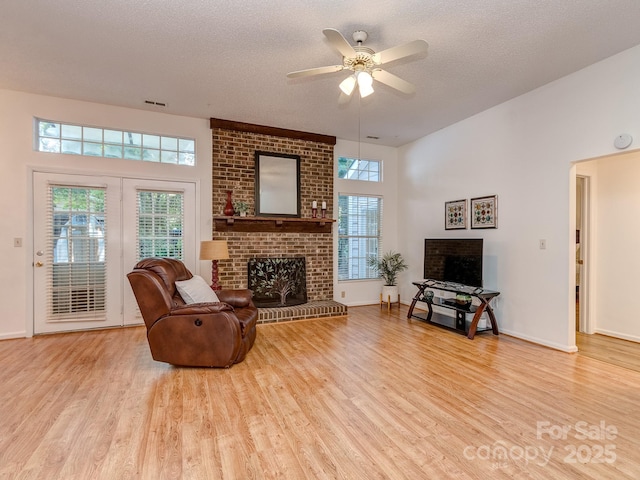 4801 Pennant Pl, Charlotte, NC 28212 - living room featuring a brick fireplace, wood finished floors, plenty of natural light, and a textured ceiling