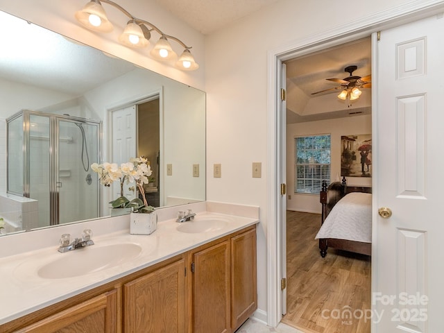 4801 Pennant Pl, Charlotte, NC 28212 - bathroom featuring double vanity, ceiling fan, a shower stall, connected bathroom, and wood finished floors