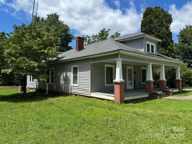 2417 Statesville Blvd, Salisbury, NC 28147 - rear view of house featuring covered porch, a lawn, and a chimney