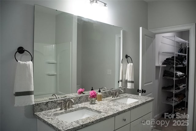 205 Spring Creek Dr, Mount Holly, NC 28120 - bathroom featuring double vanity and a walk in closet