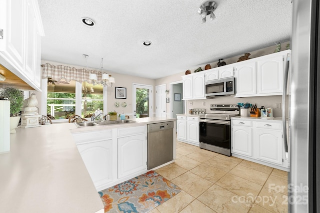 7029 Forest Hills Dr, Denver, NC 28037 - kitchen featuring appliances with stainless steel finishes, a textured ceiling, white cabinets, light countertops, and a chandelier