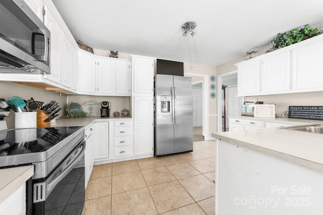 7029 Forest Hills Dr, Denver, NC 28037 - kitchen with stainless steel appliances, light countertops, white cabinetry, and light tile patterned floors