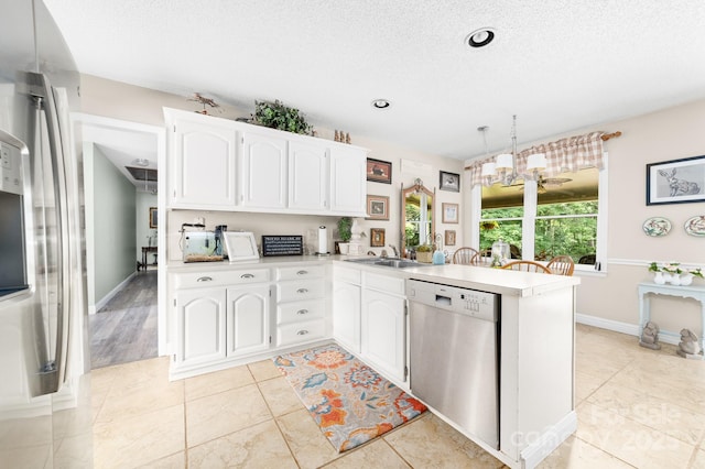 7029 Forest Hills Dr, Denver, NC 28037 - kitchen with appliances with stainless steel finishes, a peninsula, white cabinets, a chandelier, and light countertops