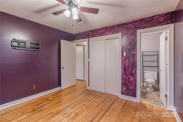1132 Arbor Dr, Salisbury, NC 28144 - unfurnished bedroom with wood finished floors, ensuite bathroom, a ceiling fan, a closet, and a textured ceiling