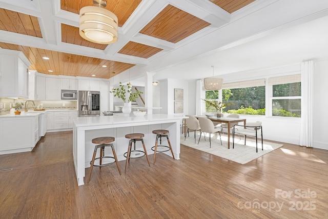 5611 Robinhood Rd, Charlotte, NC 28211 - kitchen with stainless steel fridge with ice dispenser, coffered ceiling, a breakfast bar area, light countertops, and wood finished floors