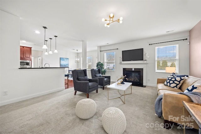 8312 Compton Acres Ln, Waxhaw, NC 28173 - living room with a chandelier, healthy amount of natural light, light colored carpet, a fireplace with flush hearth, and recessed lighting