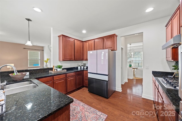 8312 Compton Acres Ln, Waxhaw, NC 28173 - kitchen with freestanding refrigerator, wood finished floors, stainless steel gas stovetop, pendant lighting, and dark stone countertops
