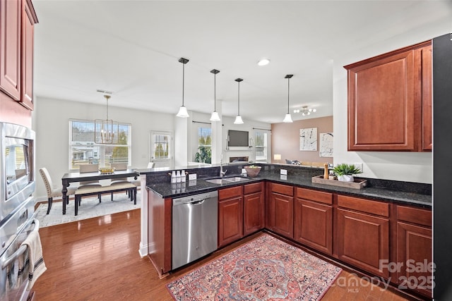 8312 Compton Acres Ln, Waxhaw, NC 28173 - kitchen with stainless steel appliances, a peninsula, dark wood finished floors, decorative light fixtures, and open floor plan