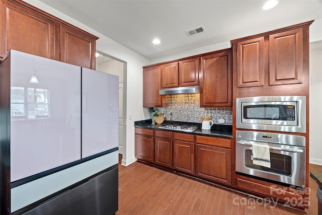 8312 Compton Acres Ln, Waxhaw, NC 28173 - kitchen with appliances with stainless steel finishes, decorative backsplash, light wood-type flooring, under cabinet range hood, and recessed lighting