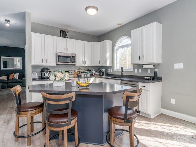 4652 Rocky Hollow Rd 4658, 4654, Davidson, NC 28036 - kitchen featuring stainless steel appliances, dark countertops, light wood-style flooring, and white cabinets