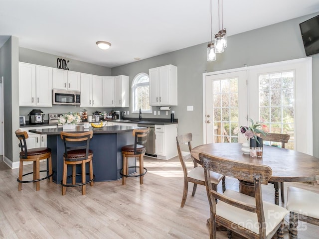 4652 Rocky Hollow Rd 4658, 4654, Davidson, NC 28036 - kitchen with appliances with stainless steel finishes, dark countertops, white cabinetry, a kitchen island, and light wood-style flooring