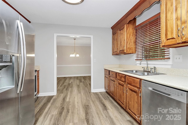 16509 Kimbolten Dr, Huntersville, NC 28078 - kitchen featuring appliances with stainless steel finishes, light wood-type flooring, light countertops, and brown cabinets