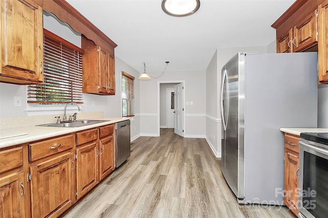 16509 Kimbolten Dr, Huntersville, NC 28078 - kitchen featuring appliances with stainless steel finishes, light countertops, light wood-style flooring, and brown cabinetry