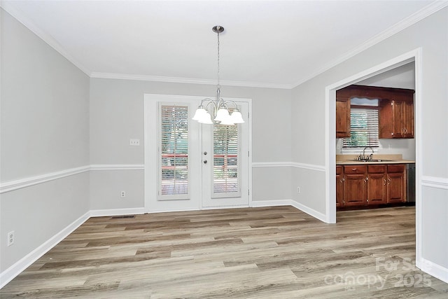 16509 Kimbolten Dr, Huntersville, NC 28078 - unfurnished dining area with a chandelier, ornamental molding, light wood-type flooring, and french doors
