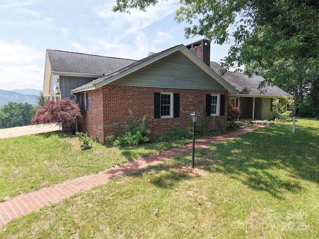 80 Gobblers Knob Dr, Clyde, NC 28721 - view of front of house with a chimney, a front lawn, brick siding, and a shingled roof